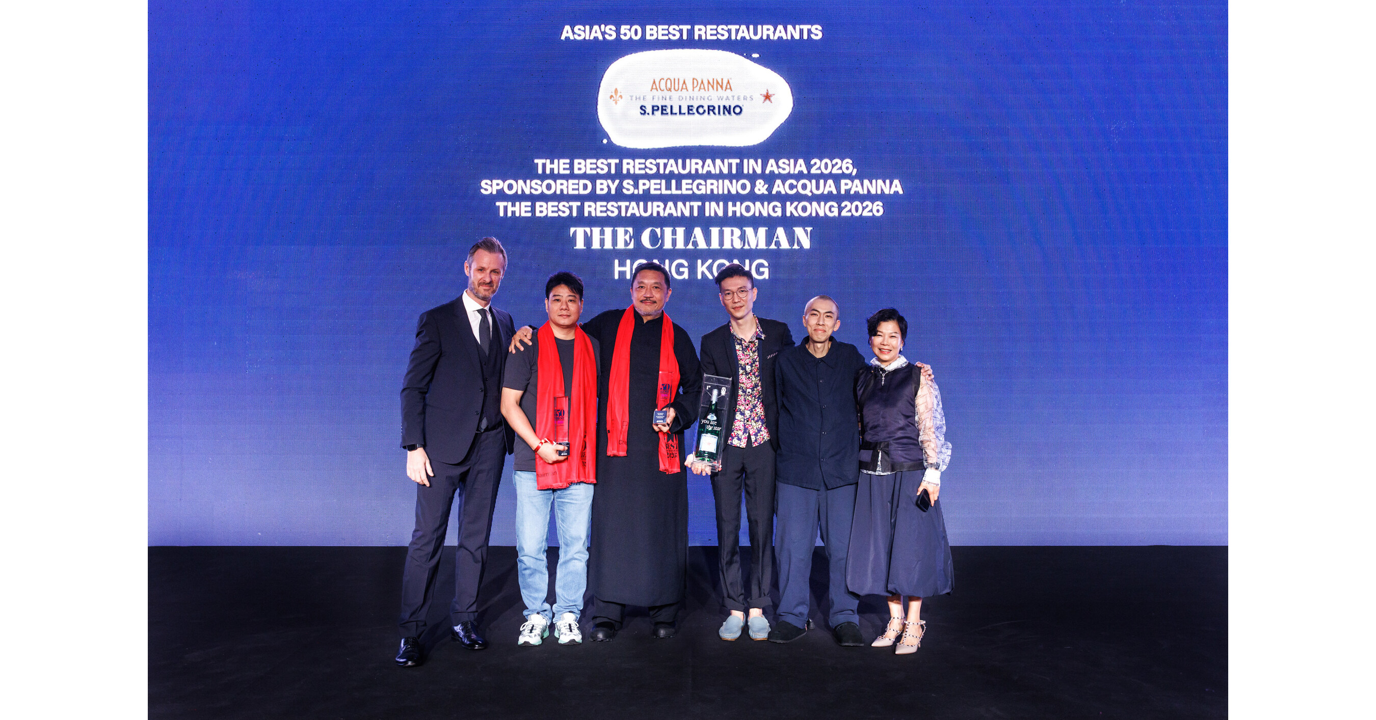 Five people stand on stage in front of blue backdrop displaying 'ASIA'S 50 BEST RESTAURANTS' and 'ACQUA PANNA S.PELLEGRINO' logos, with text referenci