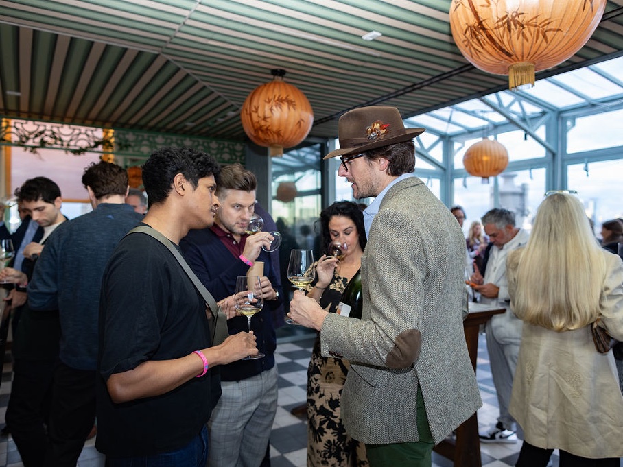 Guests converse over Champagne beneath a glass roof.