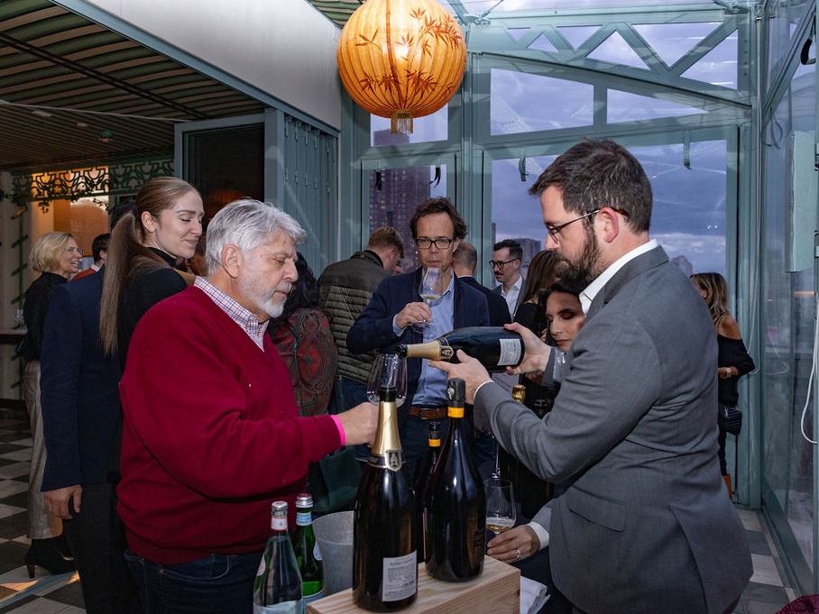 Guests talking over Champagne at the 2025 Apéro.