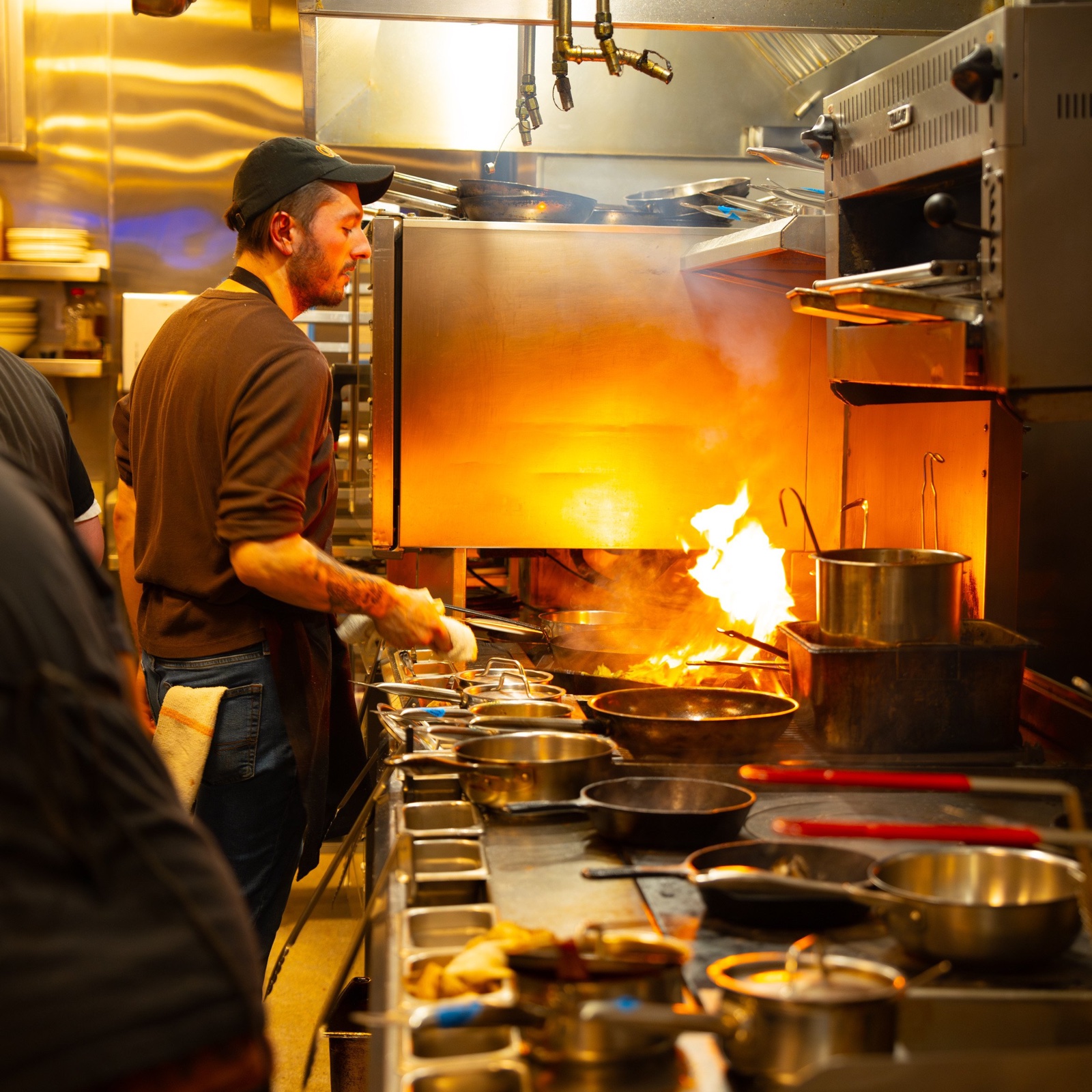 A cook works at the stove in the Obélix kitchen.